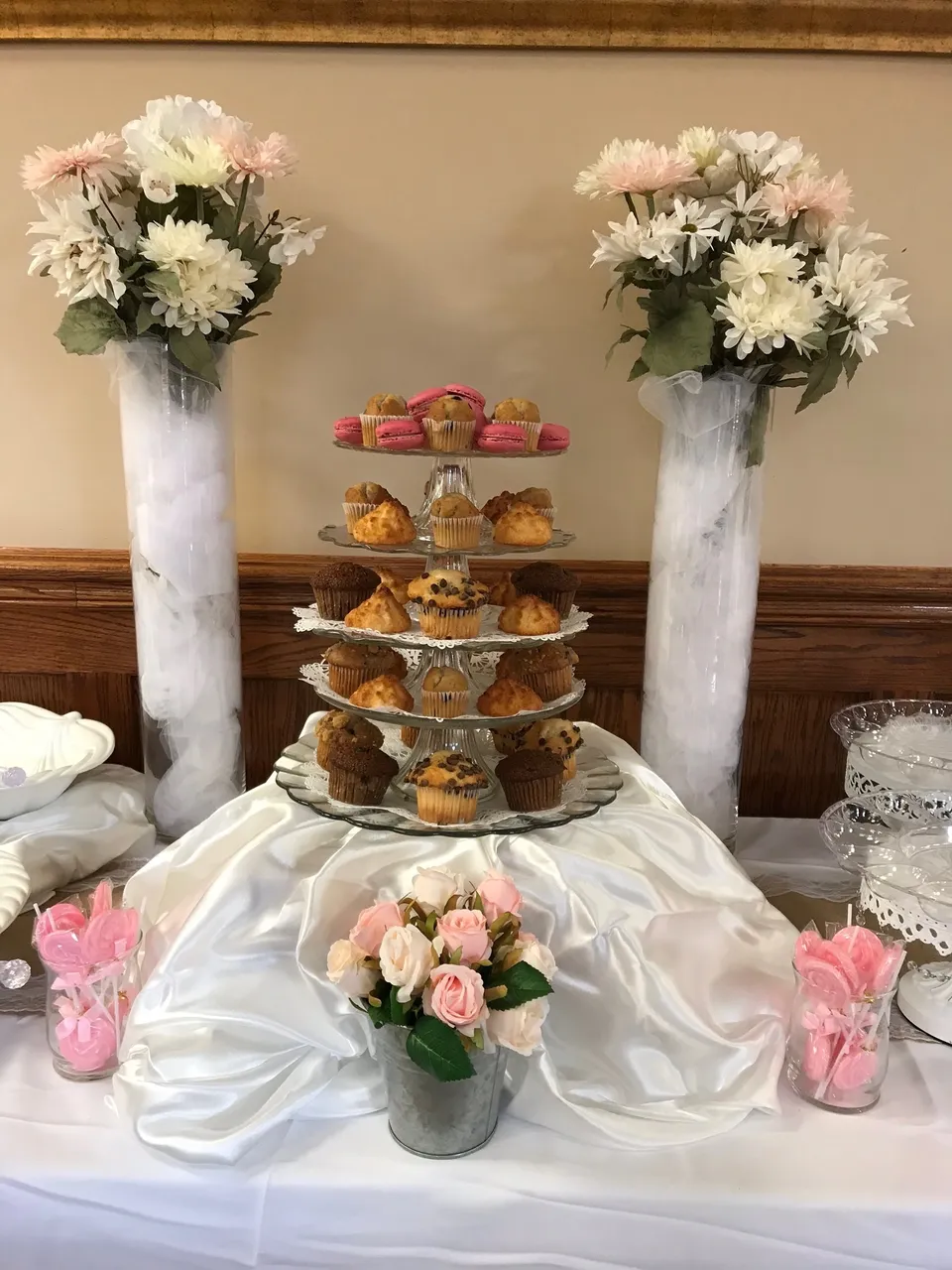 Tiered cupcake tower flanked by tall white floral arrangements