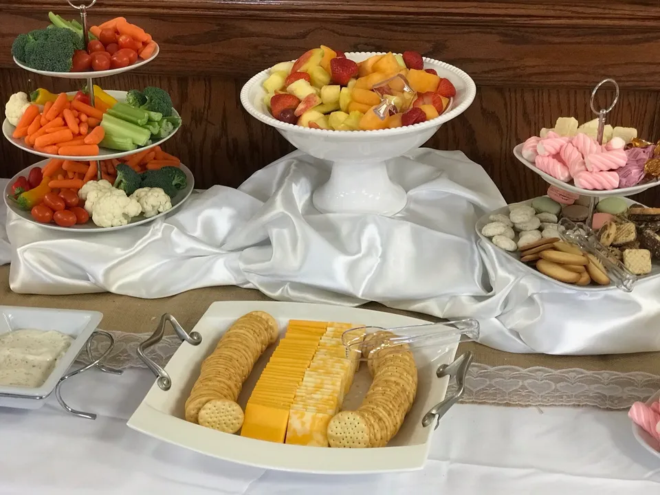 Fruit, vegetable and cheese platters on a draped buffet