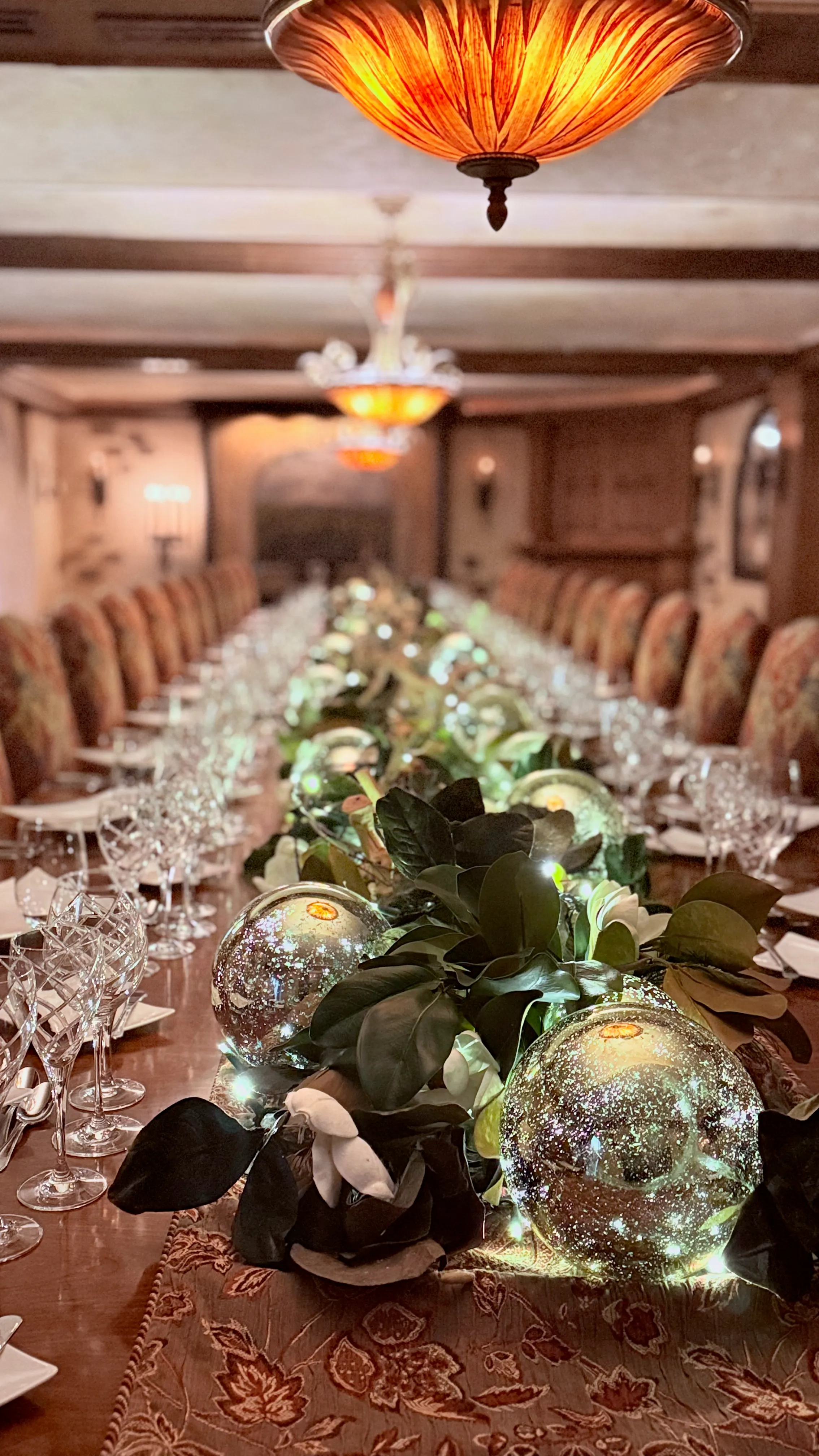 Long formal dinner table with glowing globe centerpieces by Blush & Bash