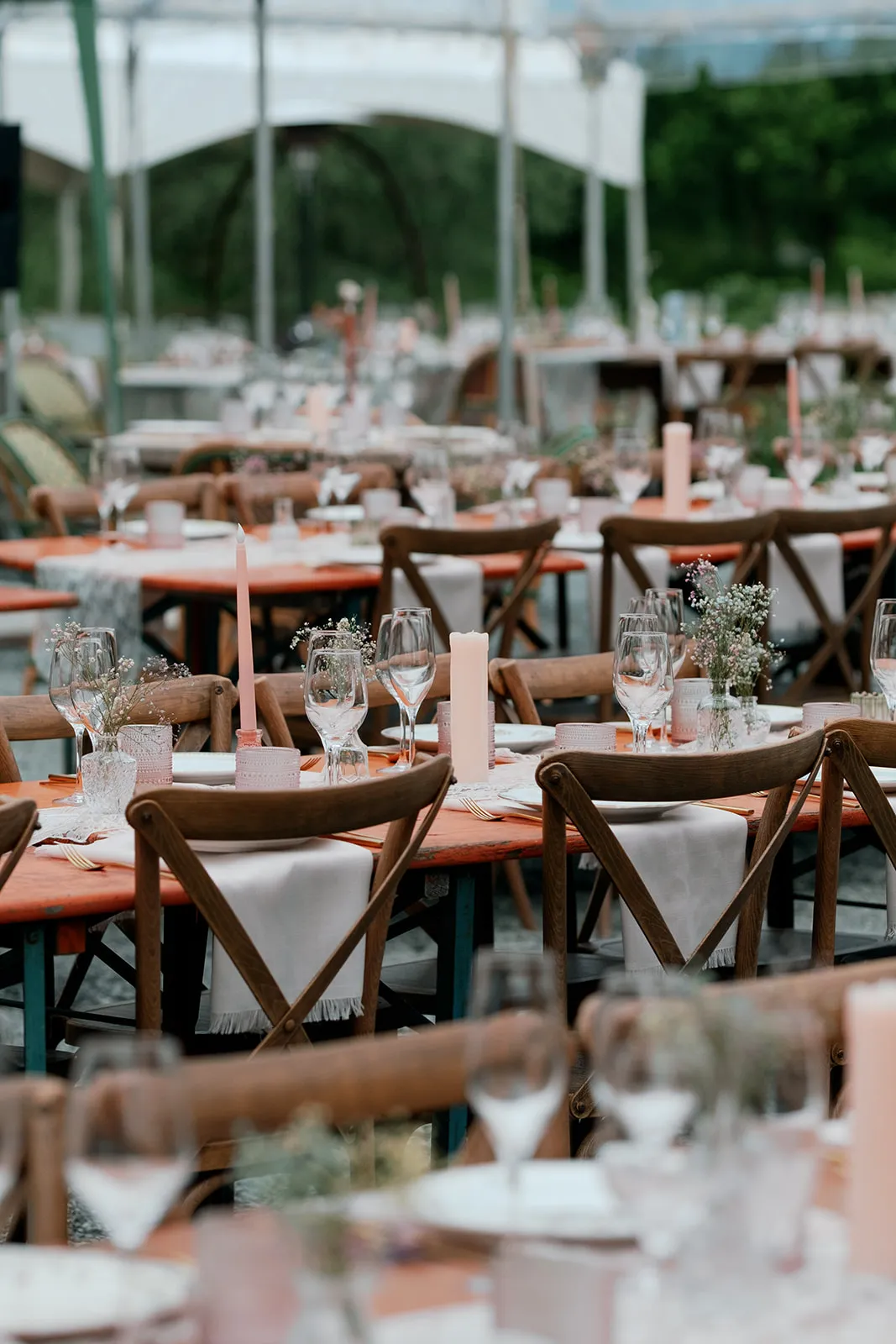 Outdoor wedding reception tables with pink taper candles and gypsophila centerpieces