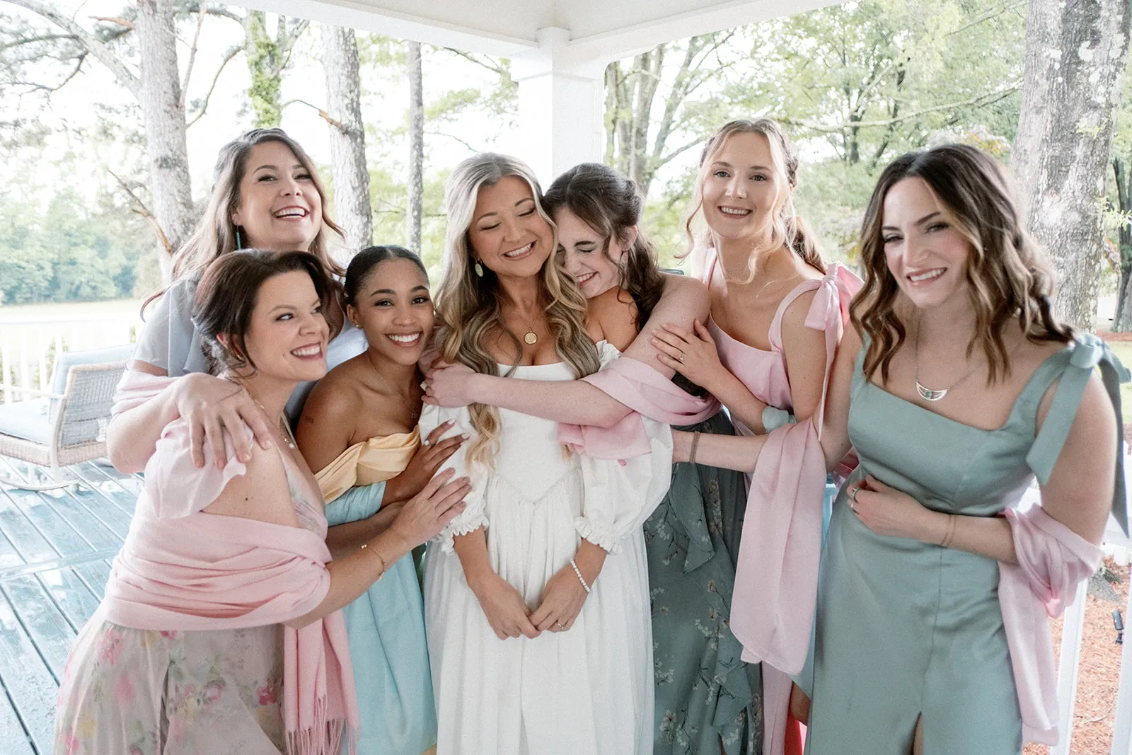 Bride and bridesmaids group hug — joyful wedding moment by Blush & Bash
